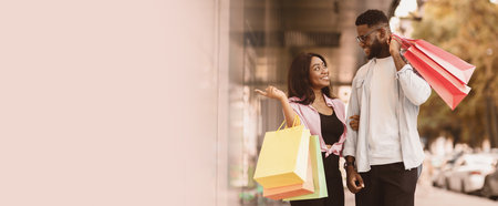 Portrait of black couple walking with shopping bags