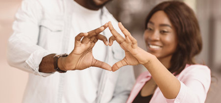 Portrait of black couple making heart shape with handsの写真素材