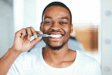 Joyful African American Guy Brushing Teeth With Toothbrush At Home