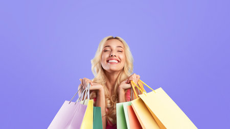 Cheerful lady holding shopping bags with new clothes