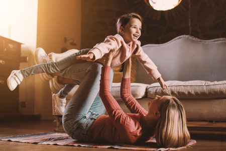 Portrait of happy woman and daughter playing togetherの写真素材