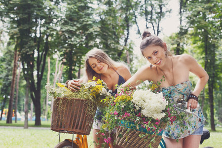 Young girls on bicycles with flowersの写真素材