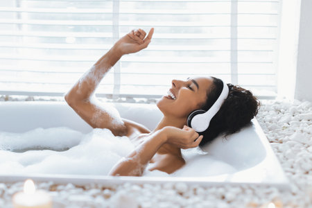 Relaxing Soak in a Bubble Bath While Enjoying Music With Headphonesの写真素材