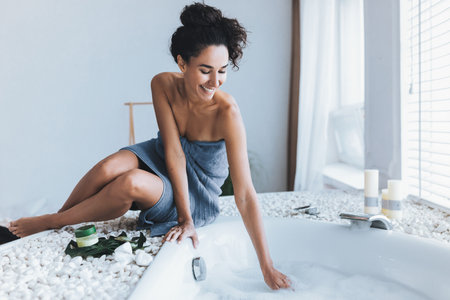 Woman Enjoying a Relaxing Bath Experience in a Bright and Modern Bathroom Settingの写真素材