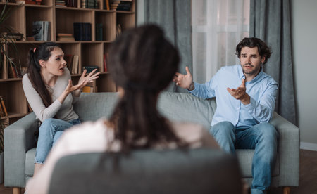 Young african american lady psychologist consults unhappy emotional european couple, husband and wife quarrelの写真素材
