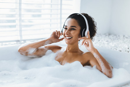 Enjoying a Relaxing Bubble Bath While Listening to Music With Headphones in Cozy Bathroom