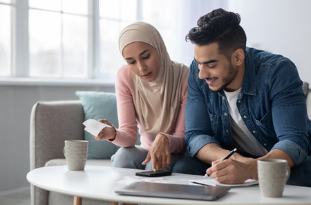 Positive muslim family counting their spendings, feeling wealthyの写真素材