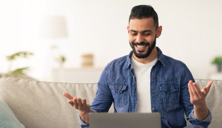 Smiling Man Engages in Virtual Meeting From Cozy Living Room During Daytimeの写真素材