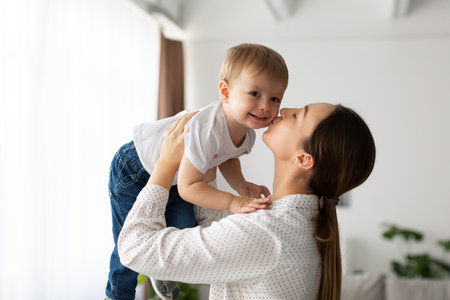 Mother and Child Share a Joyful Moment at Home While Playing Together and Bonding in a Bright, Cozy...