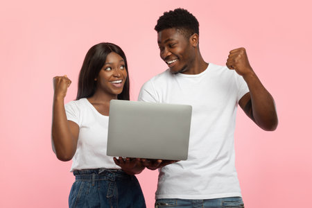 Couple Celebrates Online Success Together With Excitement and Joyの写真素材