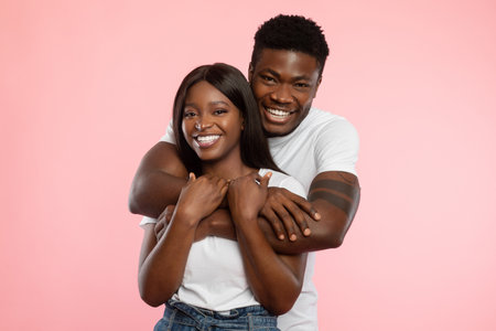 Couple in Love Share a Joyful Moment Cuddling in Front of a Pink Backgroundの写真素材