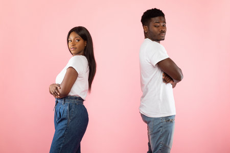 Black Couple Stands Apart After Disagreement in Pink Studio Settingの写真素材