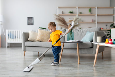 Child Happily Mops Floor While Playing in Cozy Living Room During Sunny Afternoonの写真素材