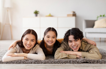 Family Enjoys Time Together on the Floor in a Cozy Living Room Settingの写真素材