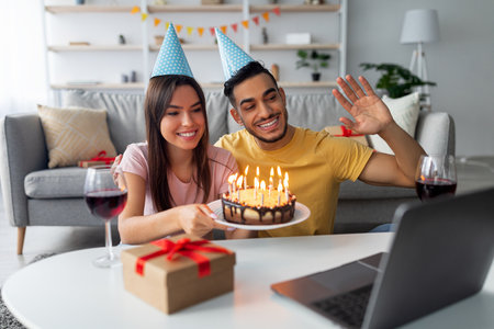 Couple Celebrates Birthday Virtually With Cake and Decorations While Preparing for Video Callの写真素材