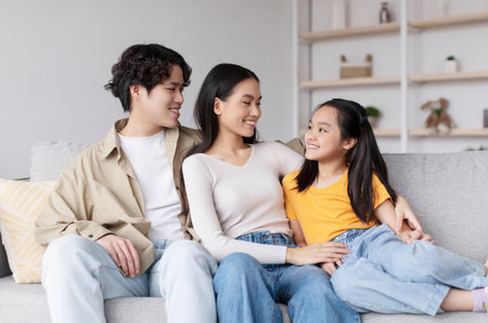 Family Spending Quality Time Together in a Cozy Living Room, Enjoying Each Others Company and Sharing Smilesの写真素材