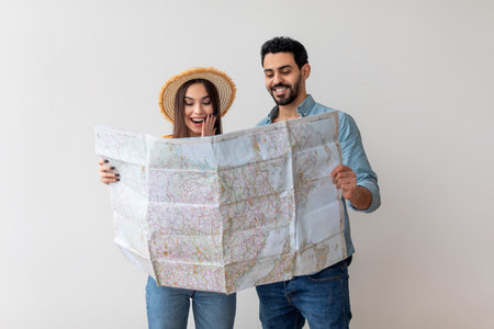 Couple Exploring Travel Plans With a Map While Smiling and Enjoying Their Adventure in a Bright Indoor Spaceの写真素材