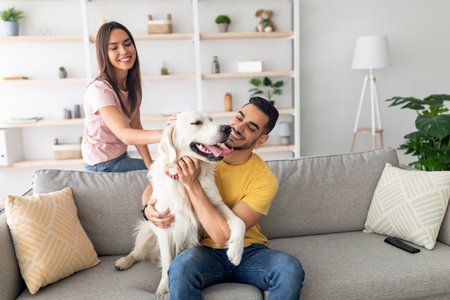 Couple Enjoys Playful Moments With Their Golden Retriever in a Cozy Living Room During a Sunny...