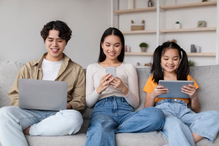 Young People Engaged in Digital Activities at Home, Showcasing Moments of Connection and Technology Use in a Cozy Living Spaceの写真素材
