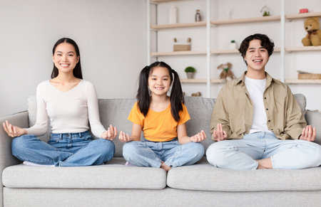 Family Practicing Meditation Together in a Cozy Living Room During a Peaceful Afternoonの写真素材