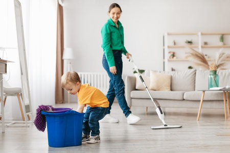 Mother and Child Cleaning Together in a Bright Living Room on a Sunny Dayの写真素材