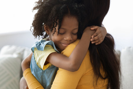 Mother and Daughter Sharing a Loving Hug Indoors During a Calm Afternoonの写真素材