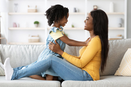 Mother and Daughter Enjoying a Joyful Moment Together at Home on a Sunny Afternoonの写真素材