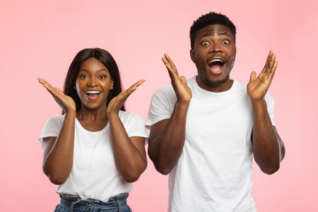 Excited Couple Celebrates Great News With Joy and Amazement in Bright Studio Settingの写真素材