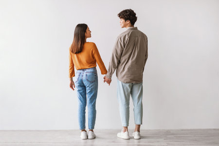 Young Asian Couple Holding Hands and Embracing Affection in Studio Settingの写真素材