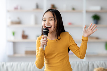 Child Performing Karaoke at Home in a Cozy Living Room During an Afternoon Gatheringの写真素材