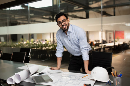 Construction Manager Reviewing Plans in Modern Office Space During the Day