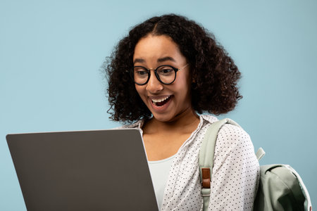 Young Woman Excitedly Engages With Remote Education on Laptop Background