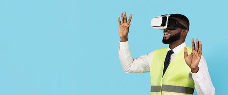 Amazed Black Male Construction Engineer Wearing VR Glasses Over Blue Background