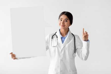 Young Indian Female Doctor Holds Blank Banner, Emphasizes Health Care Awareness During Outbreakの写真素材