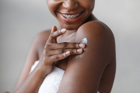 Young Woman Applies Body Lotion After Shower for Smooth, Hydrated Skin in Relaxing Settingの写真素材