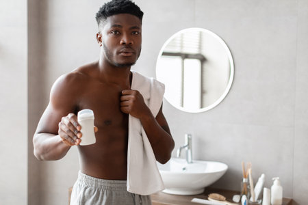 Handsome Male Promoting Sweat Protection Product in Modern Bathroom Settingの写真素材