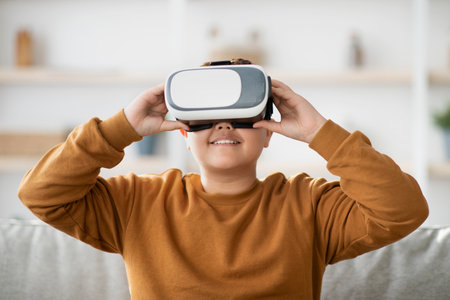 Happy Boy Enjoys Virtual Reality Experience at Home on a Cozy Couch