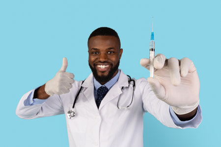 Vacination Campaign. Portrait Of Smiling Handsome Black Doctor With Syringe In Hand