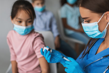 Medical Worker Vaccinates Chinese Preteen Girl Against Coronavirus Indoorsの写真素材