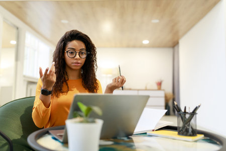 Young Woman Engaged in Serious Discussion While Working From Home in Modern Workspace Setting