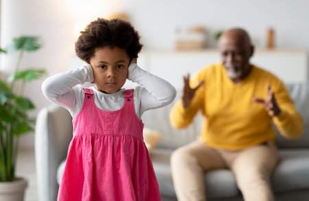 Emotional Scene With Sad Girl and Upset Grandfather in a Living Roomの写真素材
