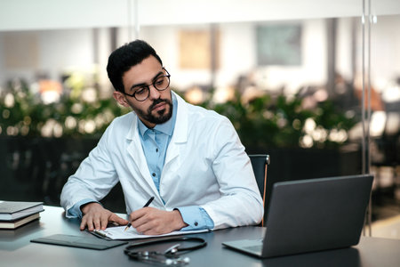 Medical Professional Working on a Laptop in a Modern Office Settingの写真素材