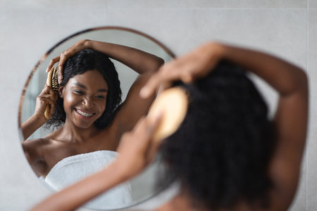 Joyful Woman Enjoying Her Haircare Routine in Bathroom Mirror Reflectionの写真素材