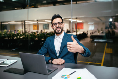 Business Professional Smiling and Giving a Thumbs up in a Modern Office Setting
