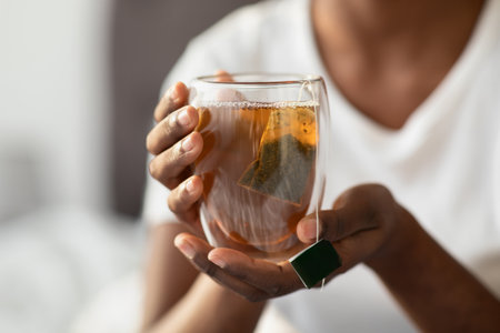Morning Tea Moment With a Lady in Pajamas Enjoying a Healthy Drink on Her Bedの写真素材