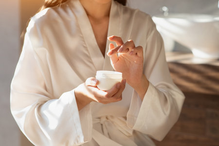 Female Hands Applying Beauty Care Product During Morning Self-Care Routineの写真素材