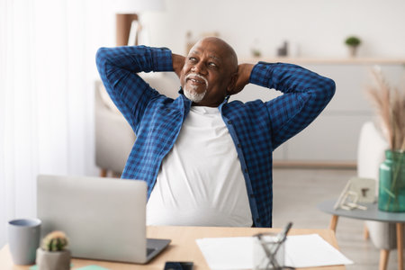 Successful Senior Businessman Enjoying a Relaxed Moment at His Modern Office Deskの写真素材