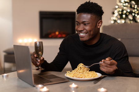 African Guy Celebrates New Year at Home With Video Call and Dinnerの写真素材