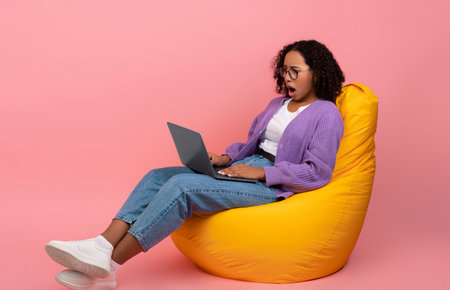 Young Woman Experiences Online Work Stress While Sitting in a Bean Bag Chairの写真素材