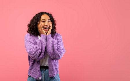 Excited Young Black Woman Expressing Joy in Pink Studio Background for Product Promotionの写真素材